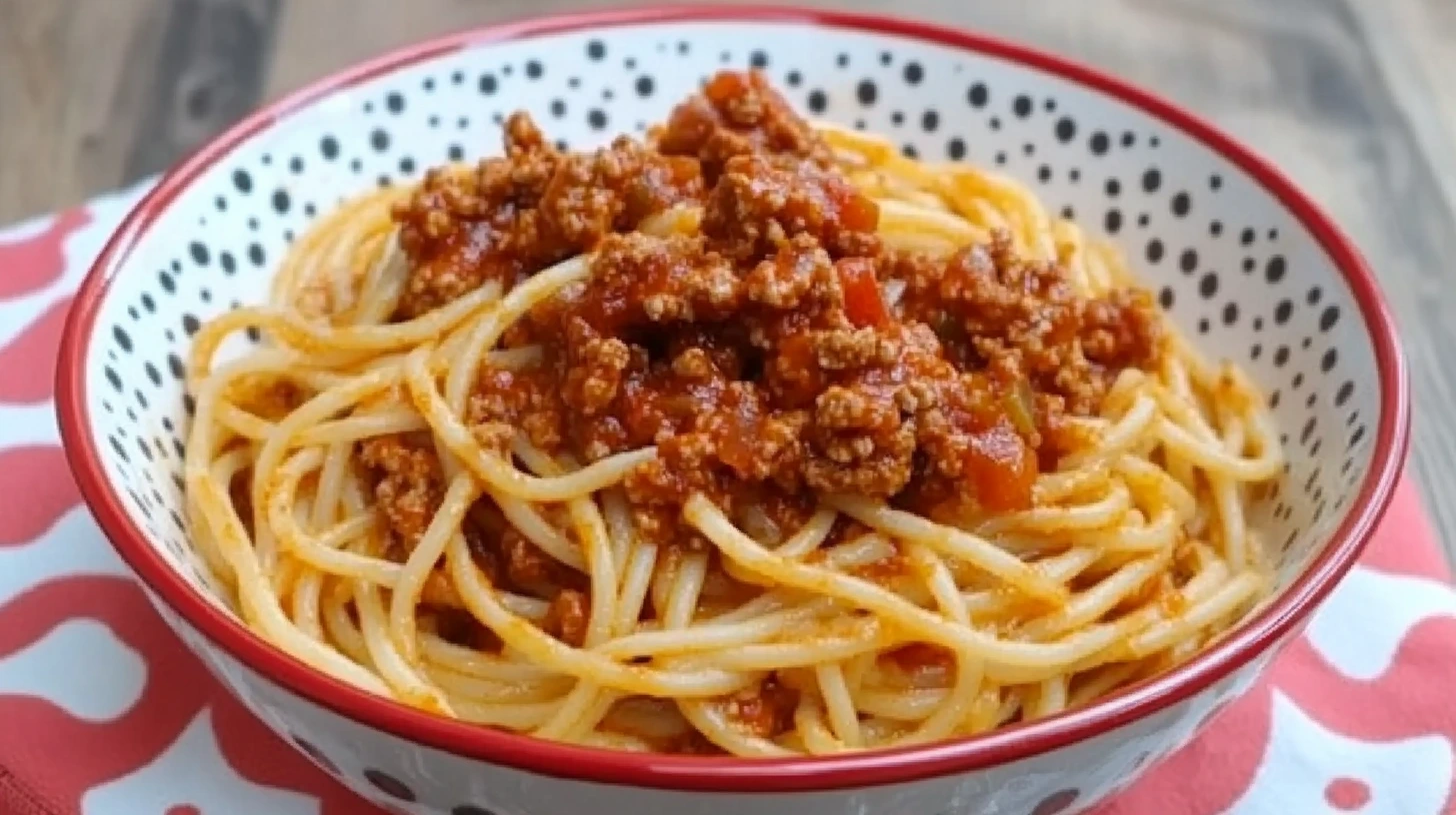 Recette Spaghetti Bolognaise Italienne traditionnelle dans un bol à motifs, sauce riche et viande hachée, prête à être dégustée.