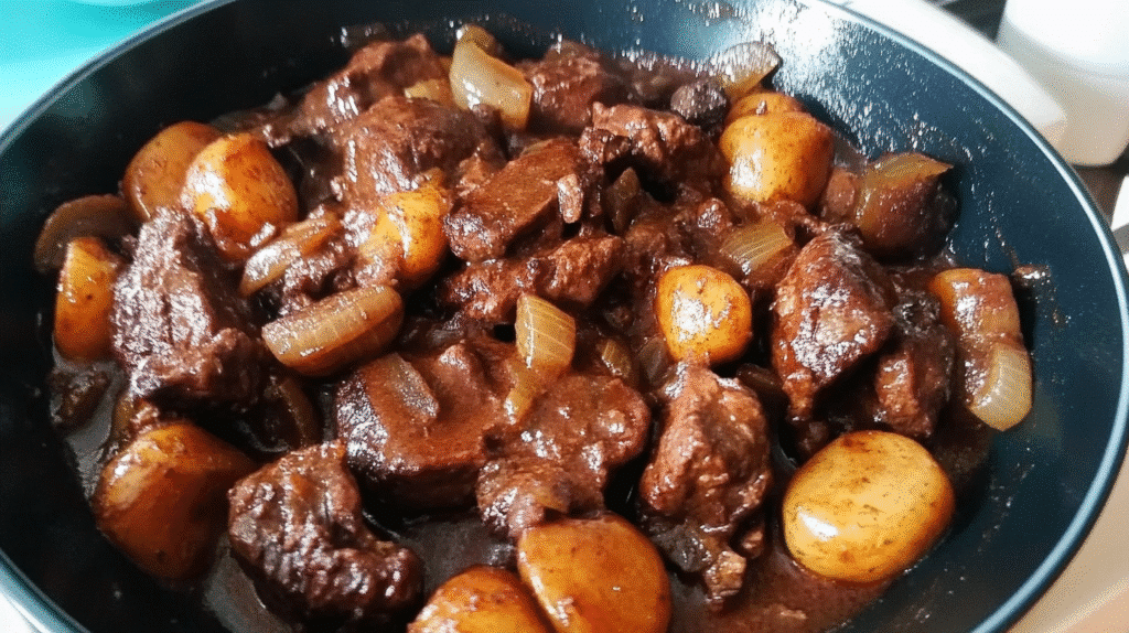 boeuf bourguignon recette de grand-mère, mijoté dans une poêle, morceaux de bœuf tendres, pommes de terre et sauce riche de SavoryGlobe.