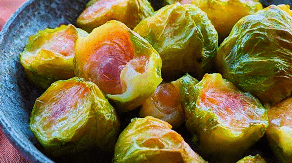 Recette choux de Bruxelles : cuisson parfaite, assaisonnement savoureux et astuces de chef 2 Plat de choux de Bruxelles rôtis, dorés et caramélisés, assaisonnés d'huile d'olive et de romarin.